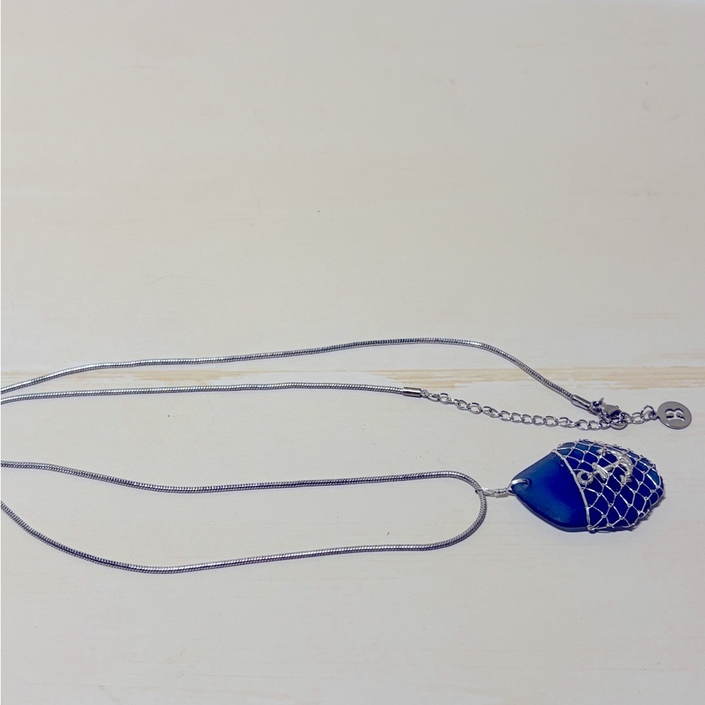 Blue stone necklace with anchor caught in the net.